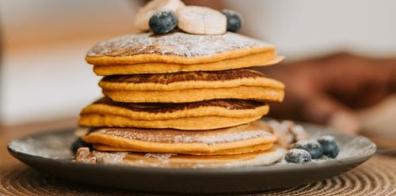 Stack of pancakes topped with blueberries 