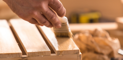 somebody polishing wood with a paint brush